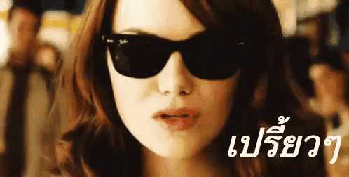 a close up of a woman wearing sunglasses with a foreign language on the bottom