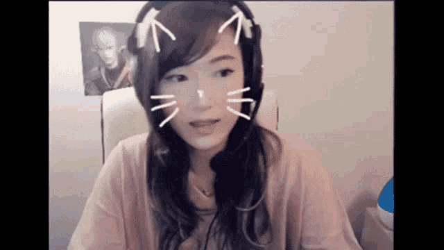 a woman wearing headphones and a cat face mask is sitting in a chair .