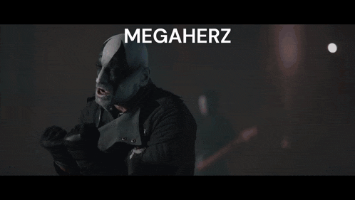 a man in a mask stands in front of a band with the word megaherz above him