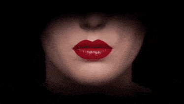 a close up of a woman 's mouth with red lipstick on it .