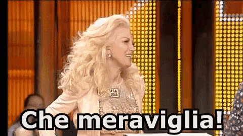 a woman with blonde hair says che meraviglia in front of a crowd