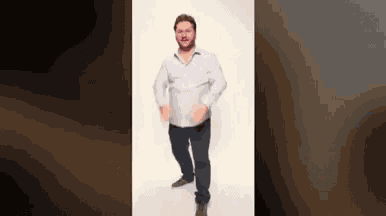 a man in a white shirt and blue jeans is dancing in front of a white background .