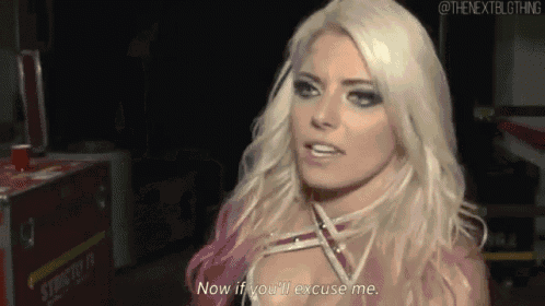 a woman with blonde hair and pink hair is talking to a man in a dark room .