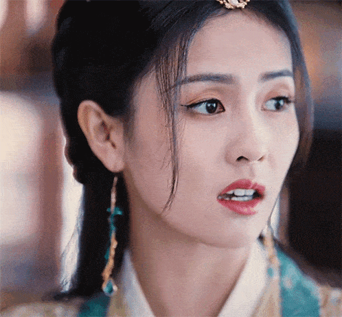 a close up of a woman 's face with earrings on