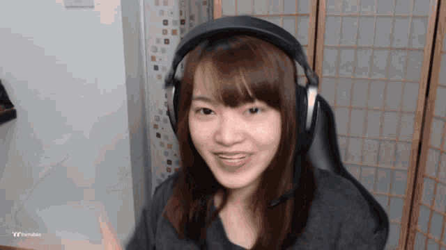 a woman wearing headphones is smiling in front of a screen that says tt trends