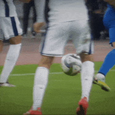 a soccer player in white shorts kicks a ball