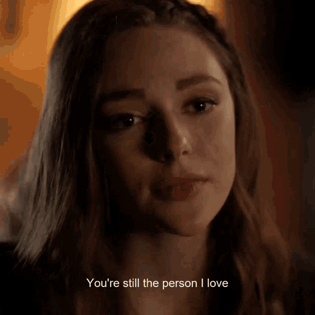 a close up of a woman with the words " you 're still the person i love " below her