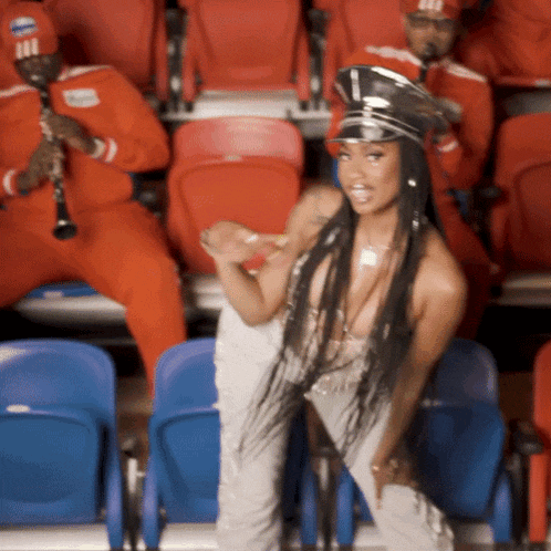 a woman wearing a hat with the number 1 on it is dancing in a stadium