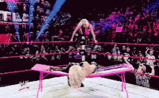 a woman is laying on a pink table in a ring