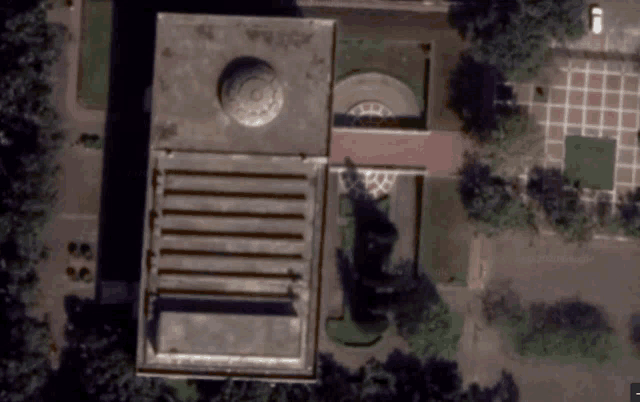 an aerial view of a building with a car parked in front