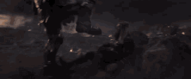 a man in a knight 's armor is fighting a group of people in a dark room .