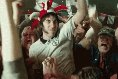 a man in a white shirt with the word england on it is surrounded by people