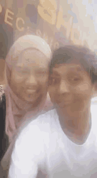 a man and a woman are posing for a picture in front of a store .