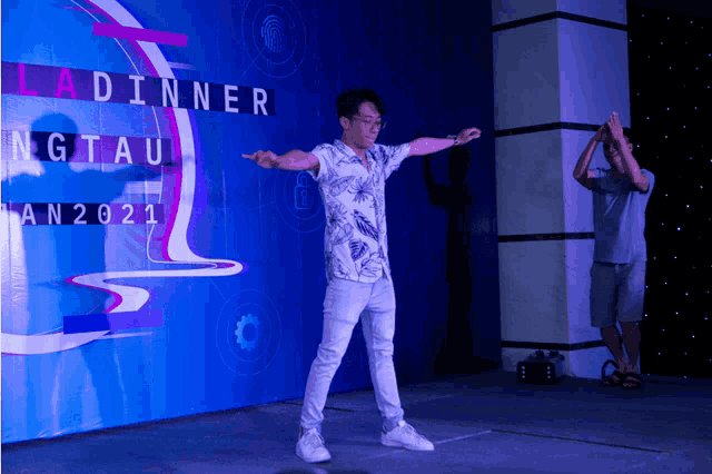 a man stands on a stage in front of a sign that says ladinner