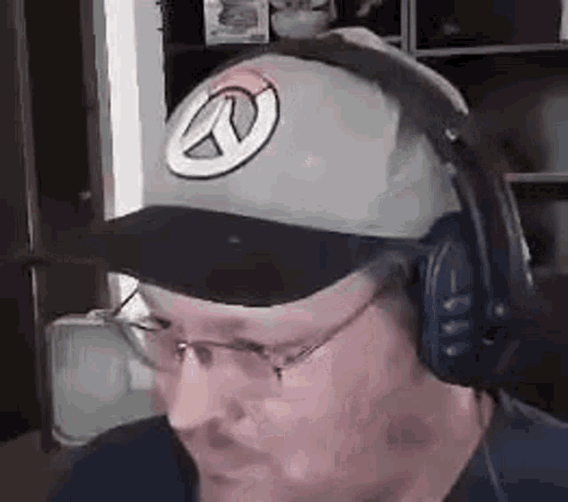 a man wearing a hat and headphones is looking at the camera .