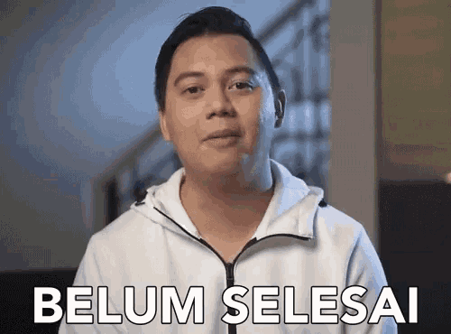 a man in a white jacket says belum selesai in white letters
