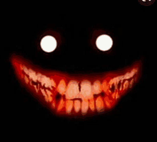 a close up of a scary face with glowing eyes and red teeth in the dark .