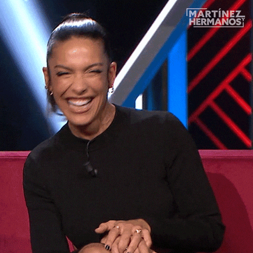 a woman is laughing in front of a martinez hermanos logo