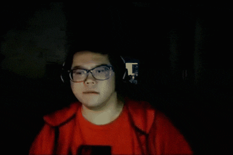 a man wearing glasses and headphones has a red shirt with the word supreme on it
