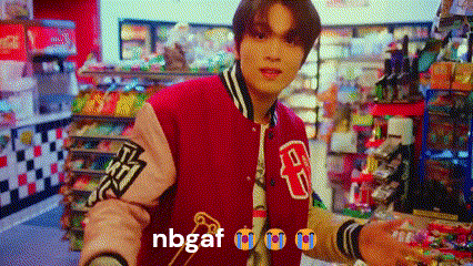 a man in a red and pink varsity jacket is standing in a store .