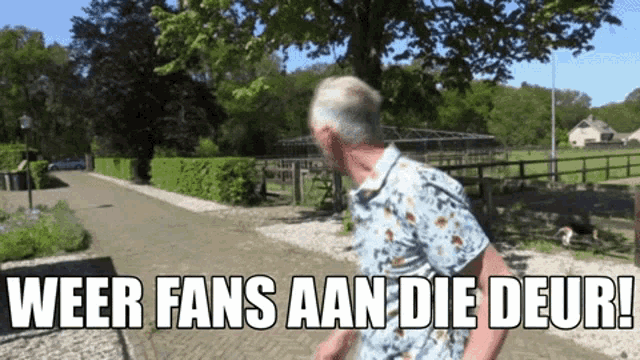 a man is walking down a street with the words weer fans aan die deur