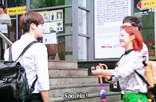 a man and a woman are standing on a set of stairs and the woman is saying soo ha !