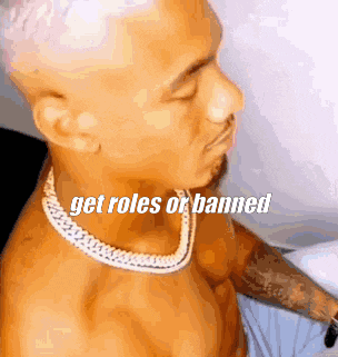 a shirtless man wearing a necklace with the words `` get roles or banned '' written above him .
