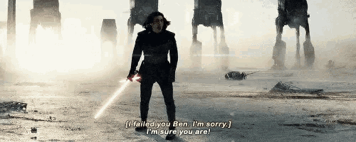 a man is holding a light saber in front of a group of at ats .