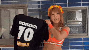 a woman holds up a shirt that says shikawa 70