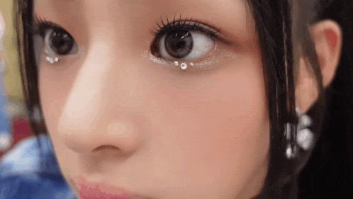 a close up of a woman 's eye with rhinestones on it