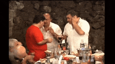 a group of men are sitting at a table with a bottle of coca cola