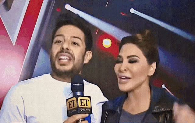 a man and a woman are talking into microphones with et on them