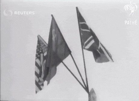 a black and white photo of three flags with the reuters logo in the background