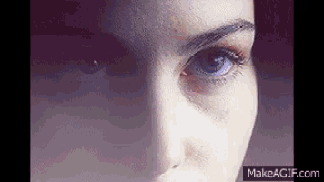 a close up of a woman 's face with blue eyes