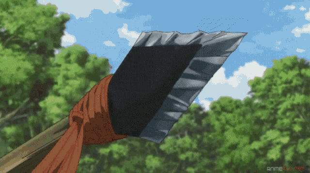a large axe with a red ribbon around it is being held up in front of trees