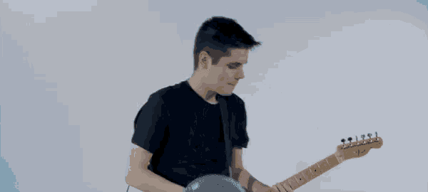 a man playing a guitar with balloons in the background