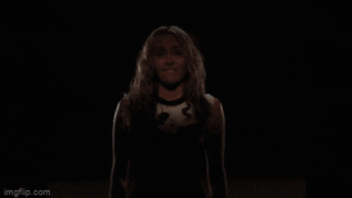 a woman singing in a dark room with imgflip.com in the lower right corner
