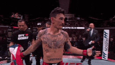 a man in a ufc hawaii shirt stands in front of a crowd