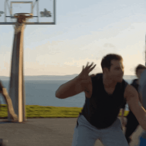 a man in a black tank top is playing basketball on a court