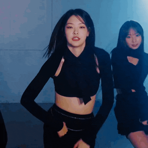 a woman in a crop top is dancing with another woman
