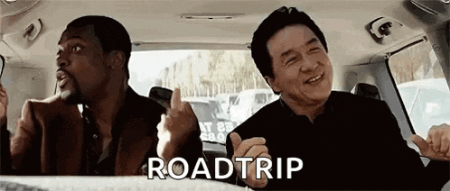 two men are sitting in the back seat of a car talking and laughing .