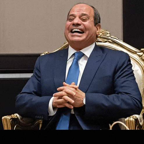 a man in a suit and tie is sitting in a chair smiling .