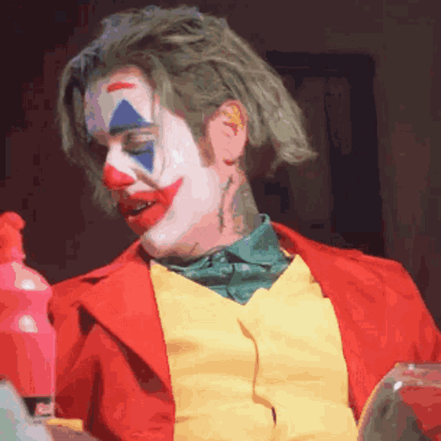 a man dressed as a clown is holding a bottle of cleaner