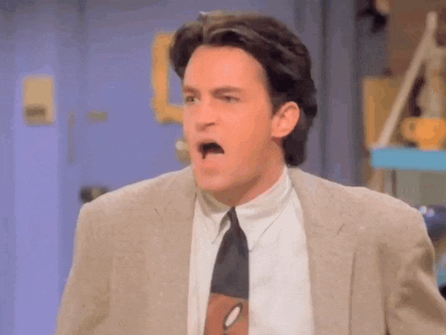 a man in a suit and tie is making a face