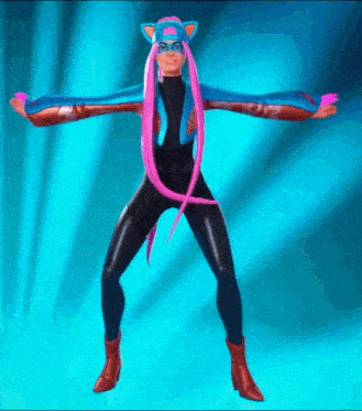 a woman in a cat costume is dancing with her arms outstretched against a blue background .