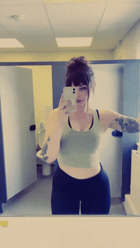 a woman taking a picture of herself in a mirror