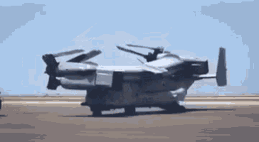 a large military jet is taking off from an airport runway .