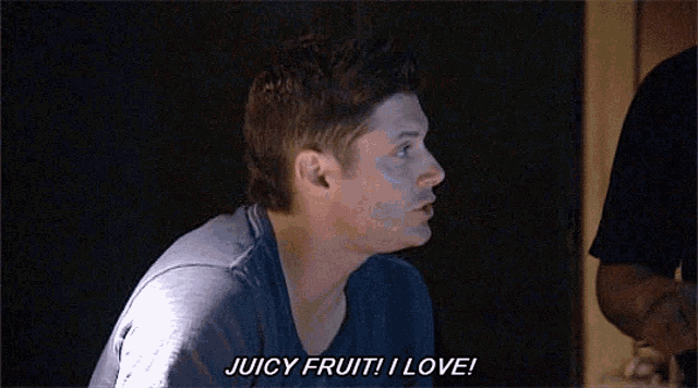 a man is saying juicy fruit i love in a dark room .
