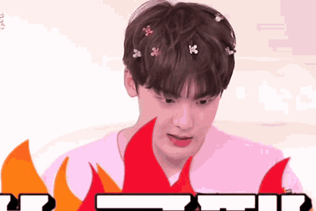 a young boy with flowers in his hair is surrounded by fire .