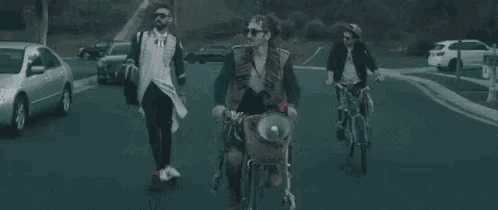 a group of people are riding bikes down a road .